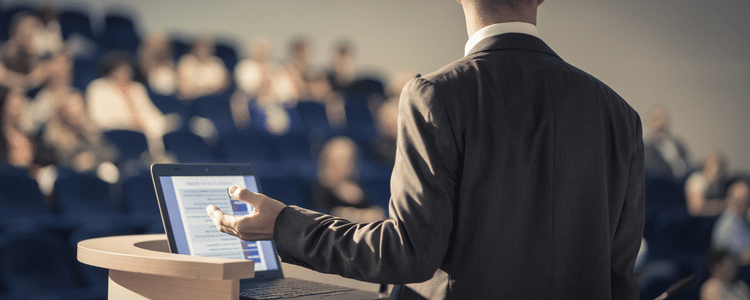 Man talking in a lecture theatre with his back to the camera