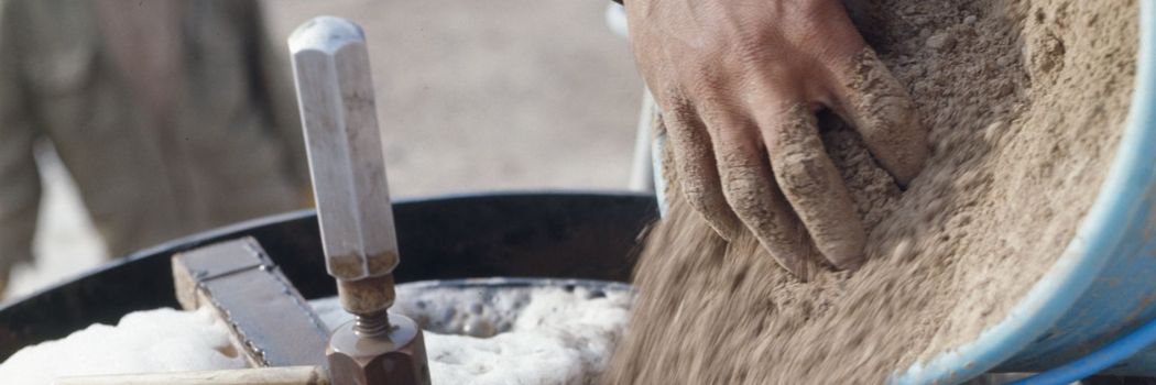 A person pours soil into a flotation machine to extract carbonised plant remains