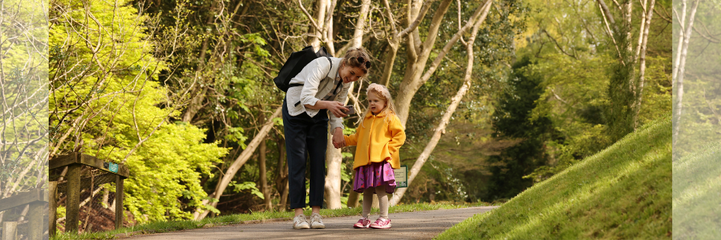 A woman and child on a tree-lined pathway