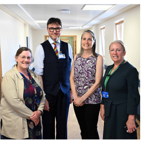 Chancellor Dr Fiona Hill smiling with officials in a corridor