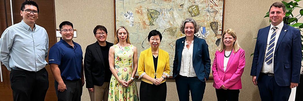 Colleagues standing together in front of a painting