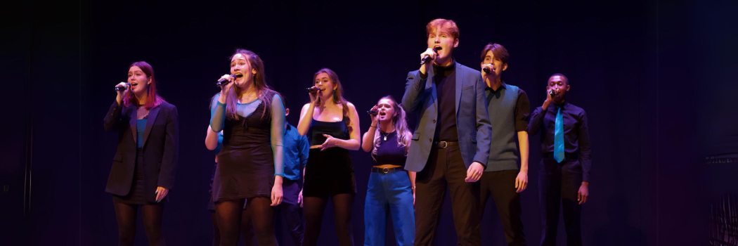 Group of students on stage, singing