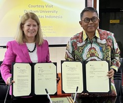 Two colleagues holding signed documents