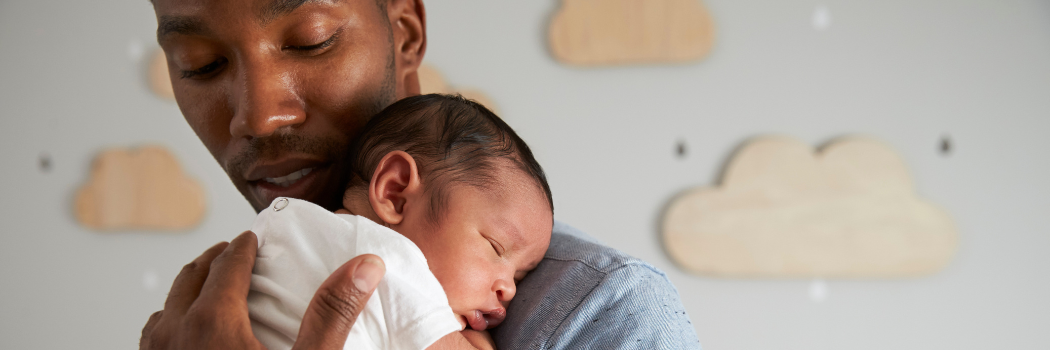 A man holding a baby over his shoulder