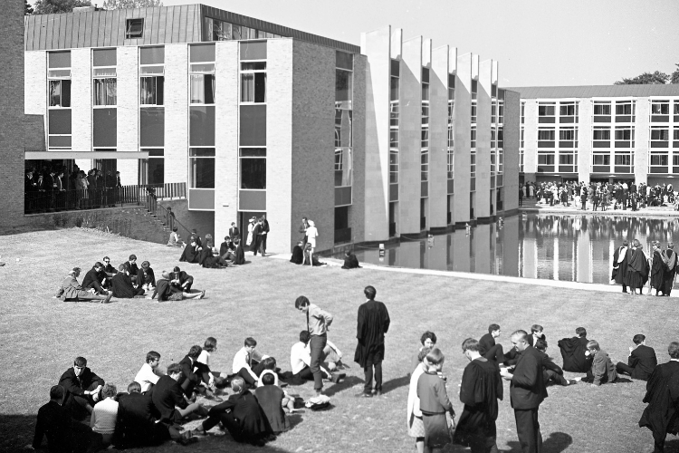 Black and white image of students gathering in front of college