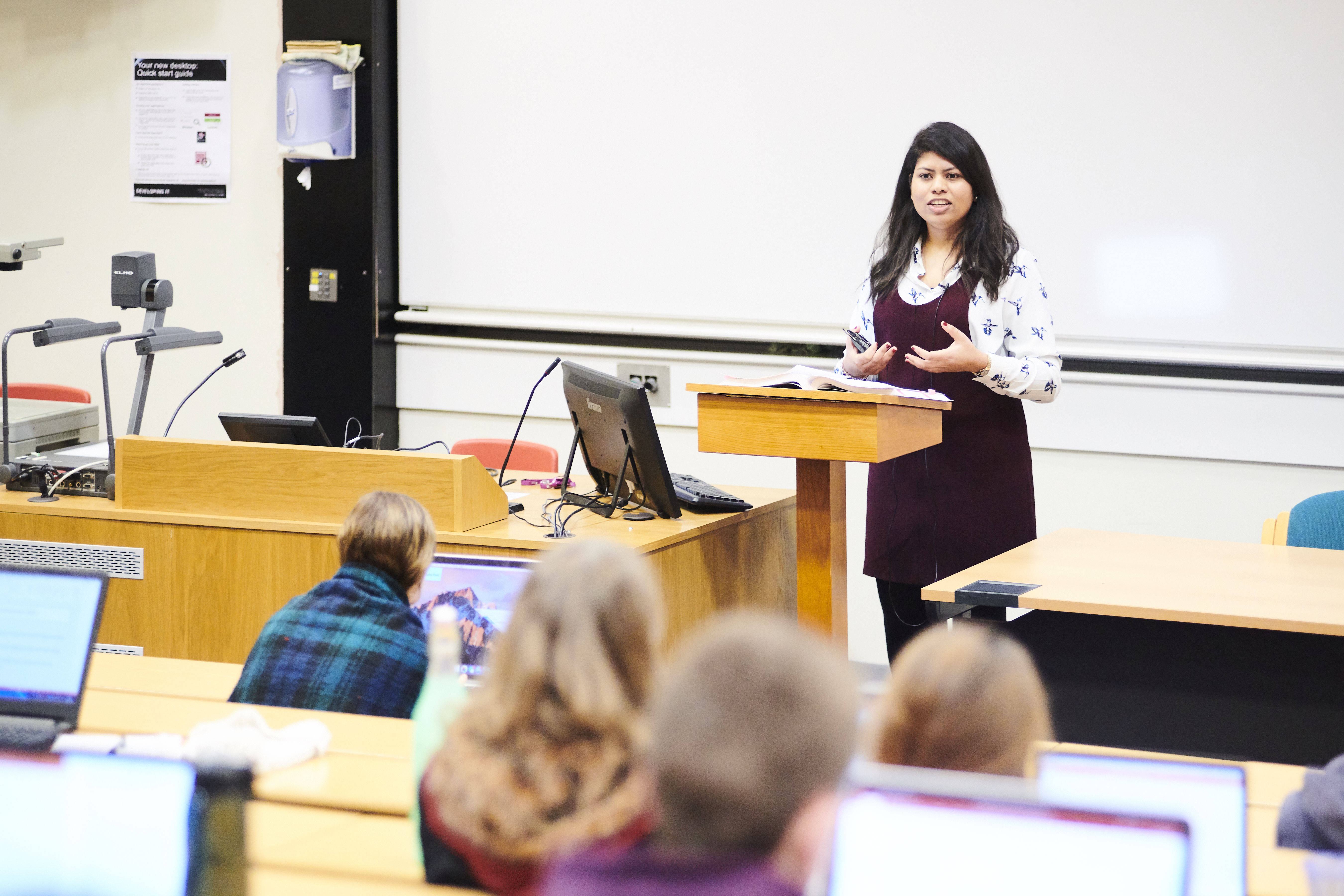 Someone at a lectern in a lecture theatre