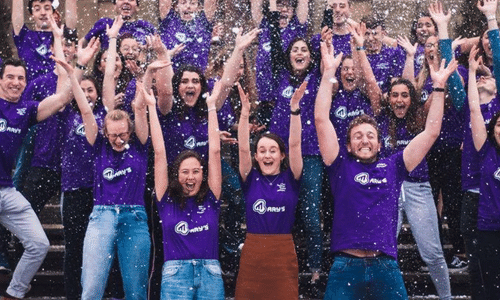 A group of St Mary's students with arms raised in the air