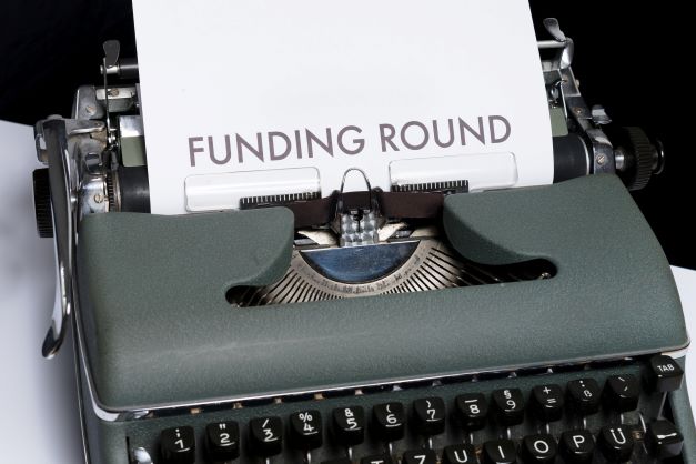 Typewriter with funding round on paper