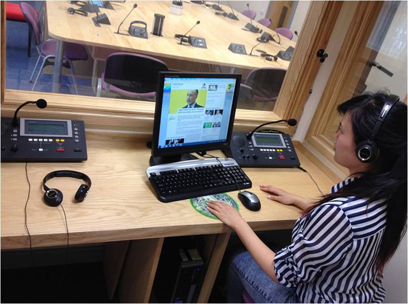 A student working on a computer in an interpreting booth