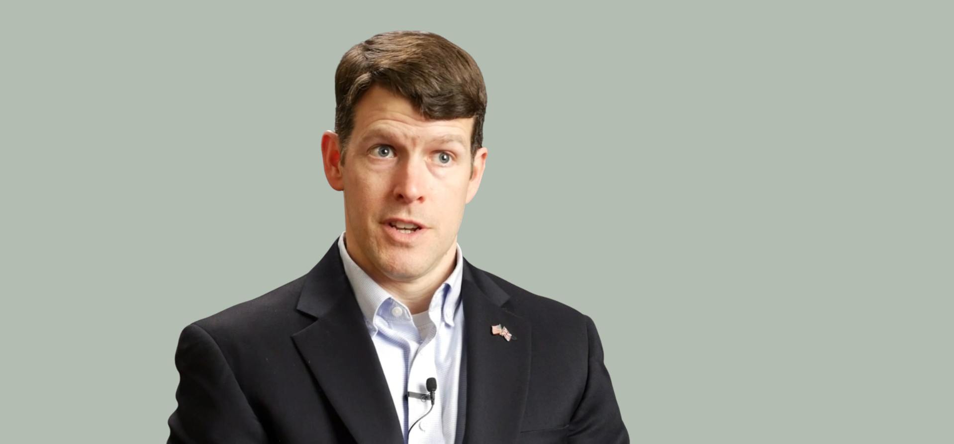 A man with short dark hair speaking during an interview