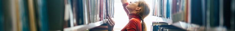 Girl in library reaching for books