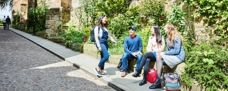 Students sat outside on a Durham street talking