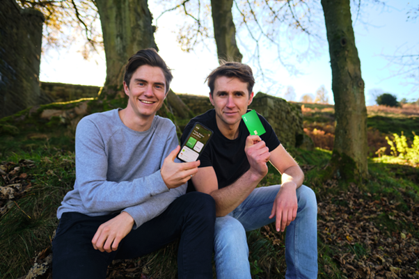 Two students holding up their innovative bank card