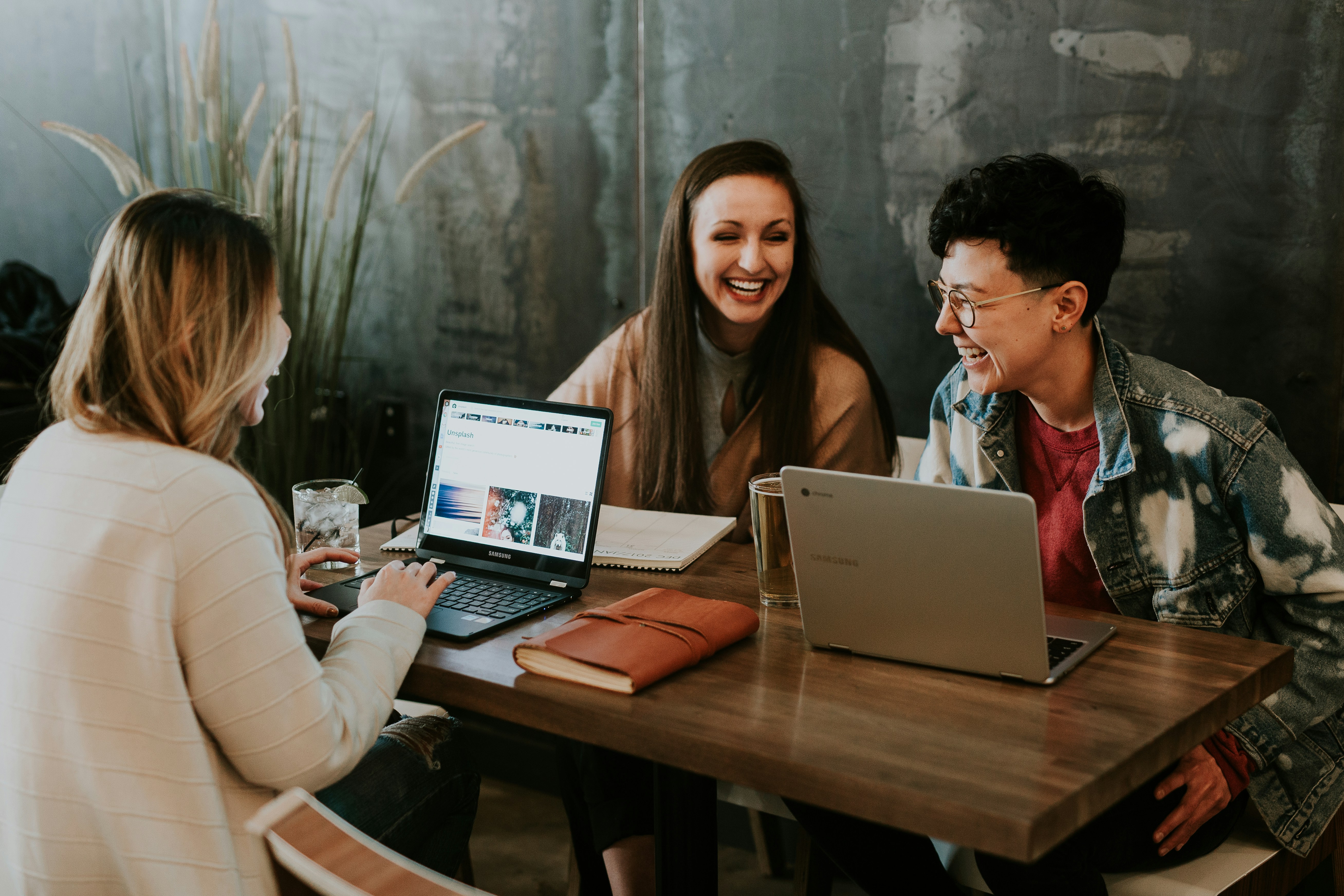 A group of young professionals sits around computers chatting